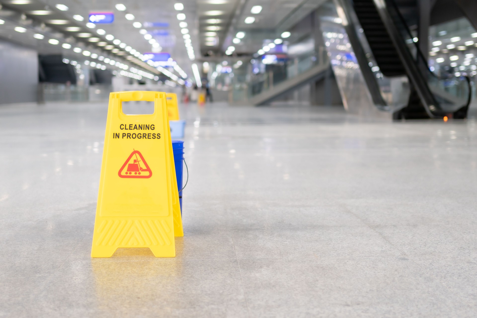 yellow plastic cone with sign showing warning of wet floor in restaurant in department store